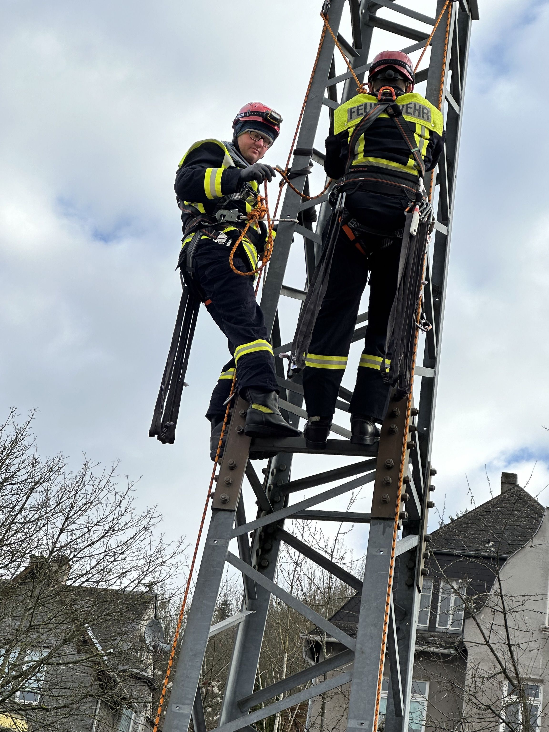 Zwei Feuerwehrangehörige auf Gittermast