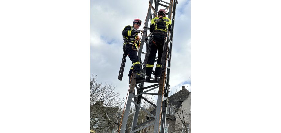 Zwei Feuerwehrangehörige auf Gittermast