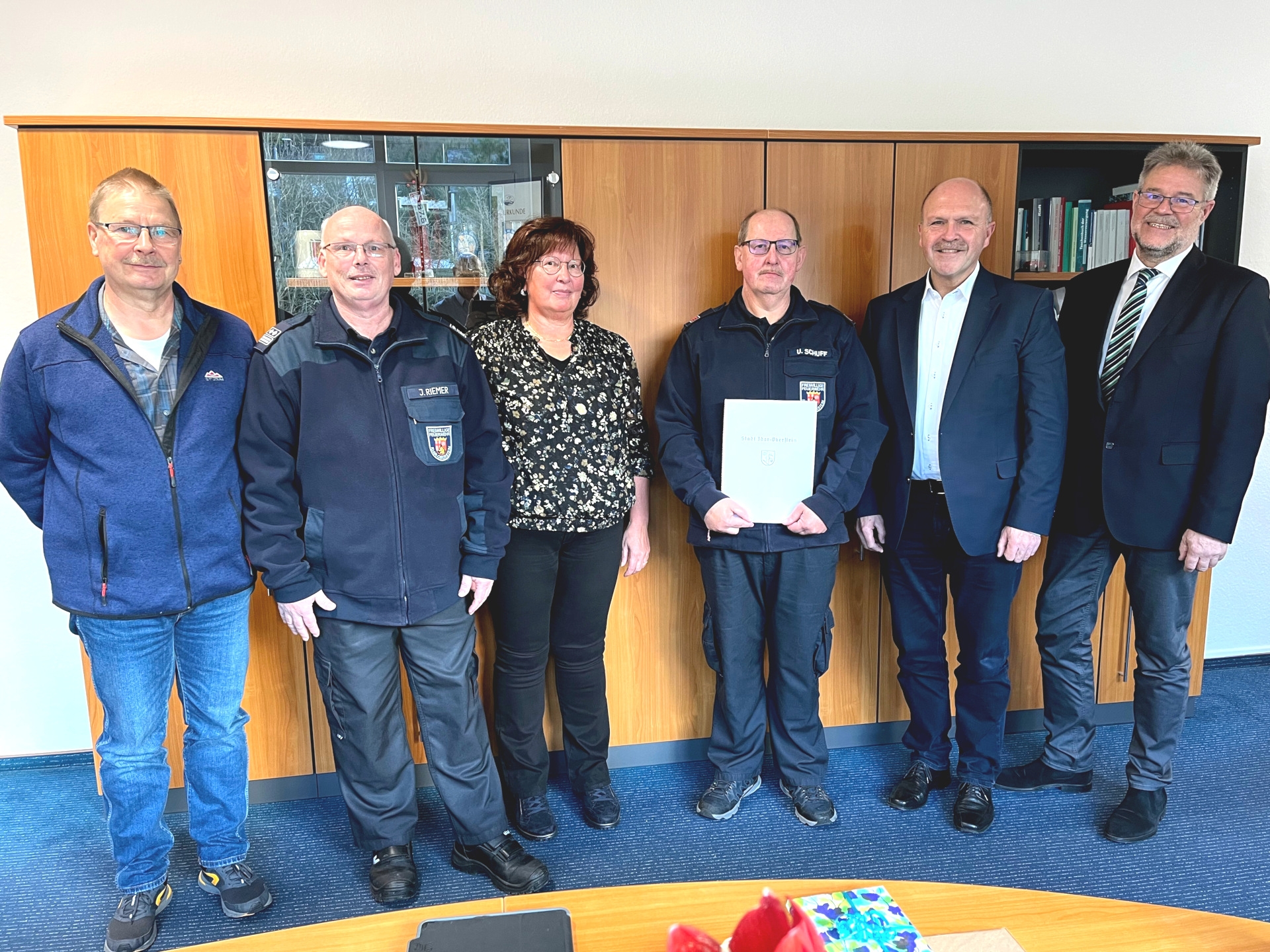 Das Foto zeigt sechs Personen, darunter Udo Schuff. Sie stehen nebeneinander im Büro von Bürgermeister Marx und blicken in die Kamera. Udo Schuff hält die Dankurkunde in den Händen.