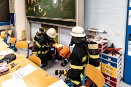 Verletzter Schüler im Klassenzimmer wird von Feuerwehrangehörigen gerettet