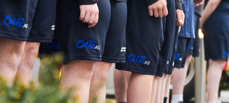 Jugendliche mit kurzen Hosen und OIE Logo