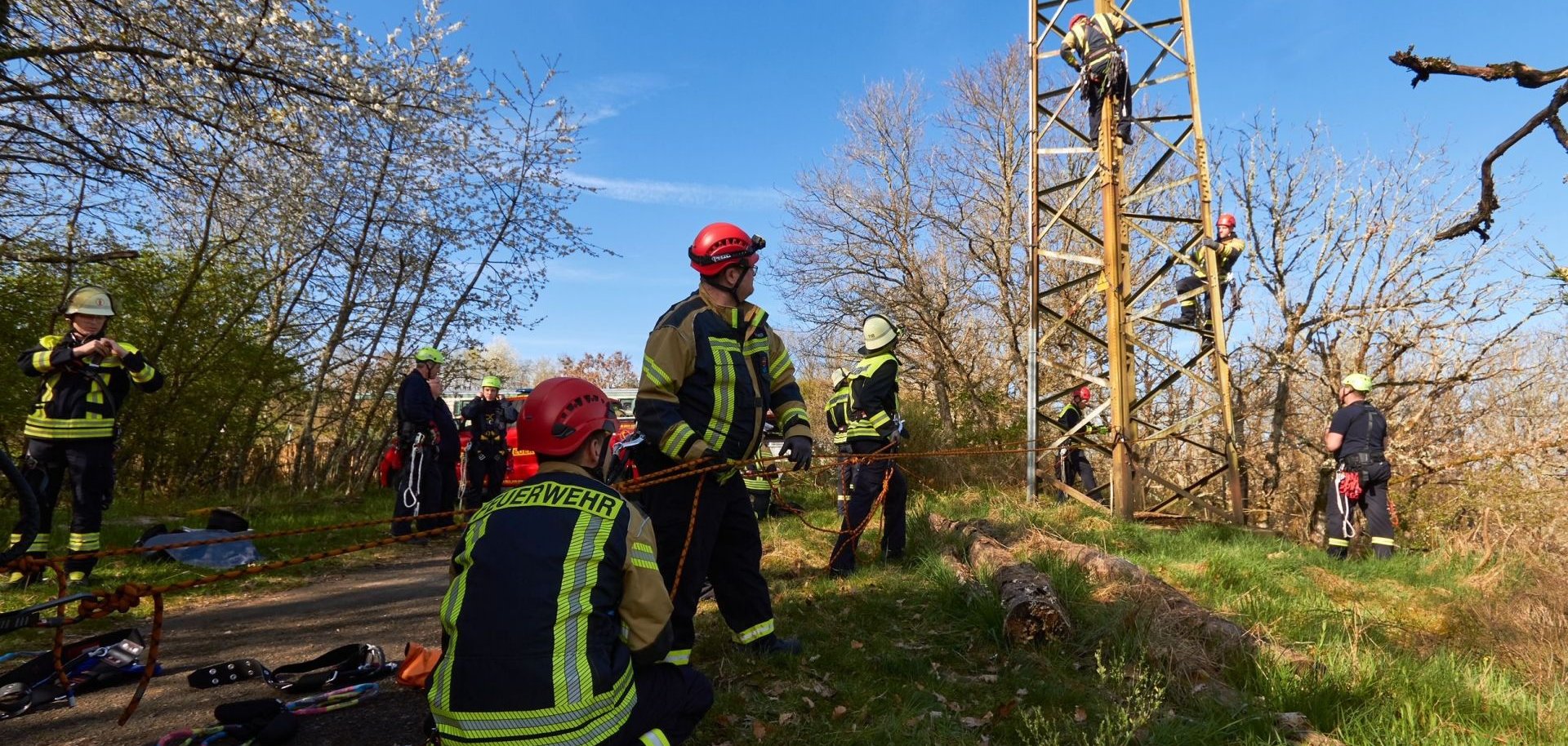 Feuerwehrangehörigen üben am Hochspannungsmast