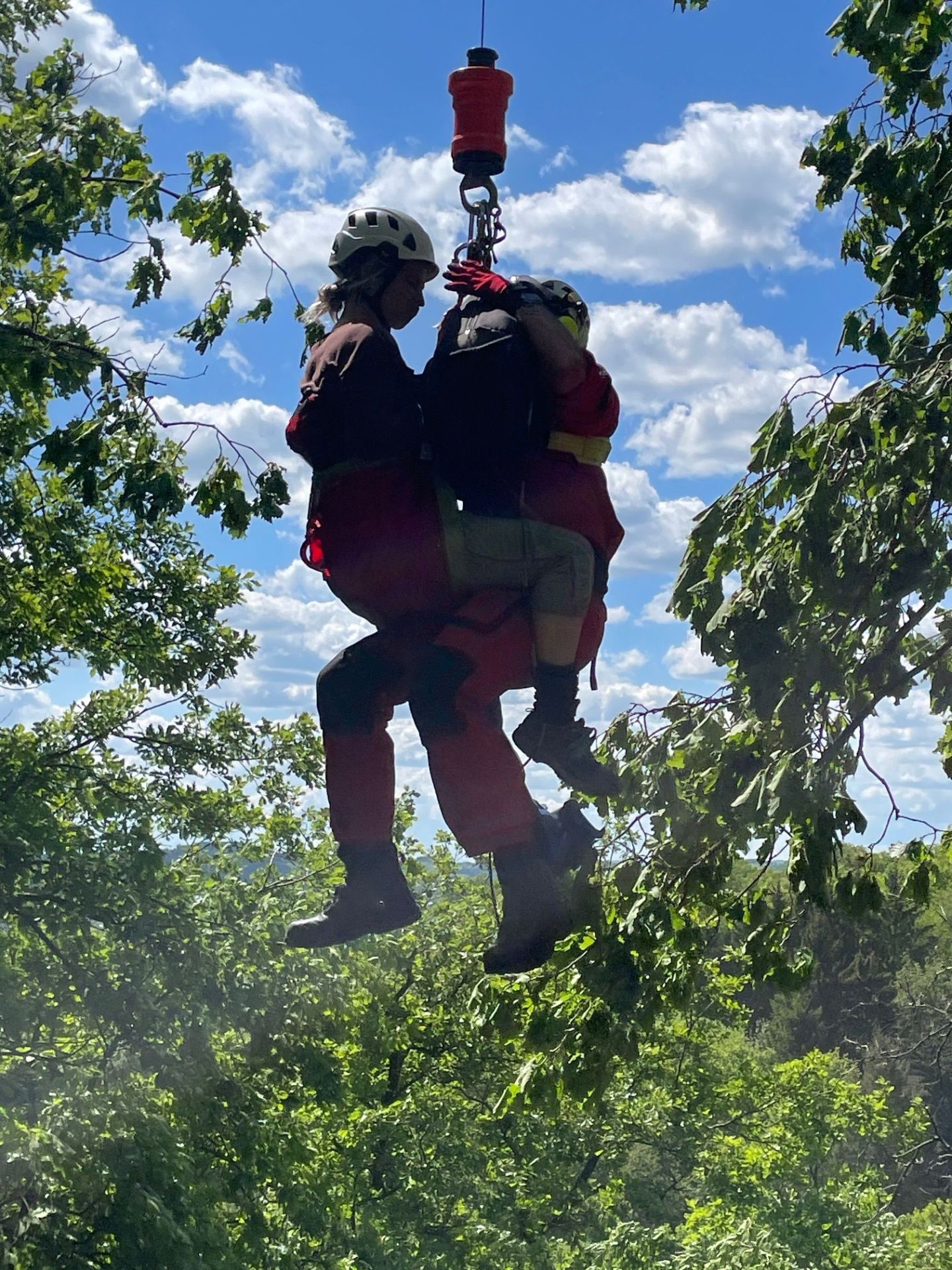 Notarzt und Patient an der Seilwinde des Hubschraubers