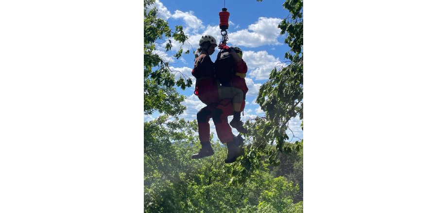 Notarzt und Patient an der Seilwinde des Hubschraubers