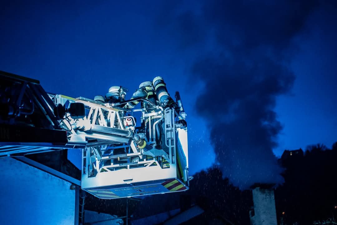 Qualmender Schornstein; Drehleiterkorb mit Feuerwehrangehörige 