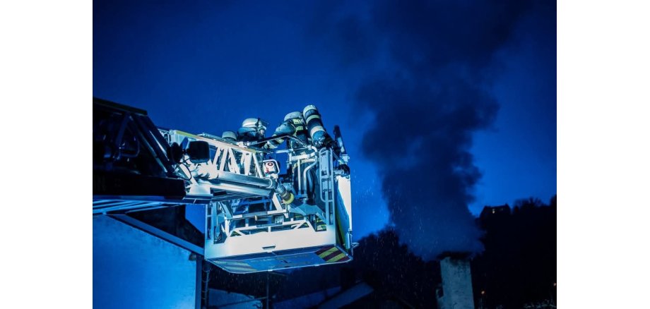 Qualmender Schornstein; Drehleiterkorb mit Feuerwehrangehörige 