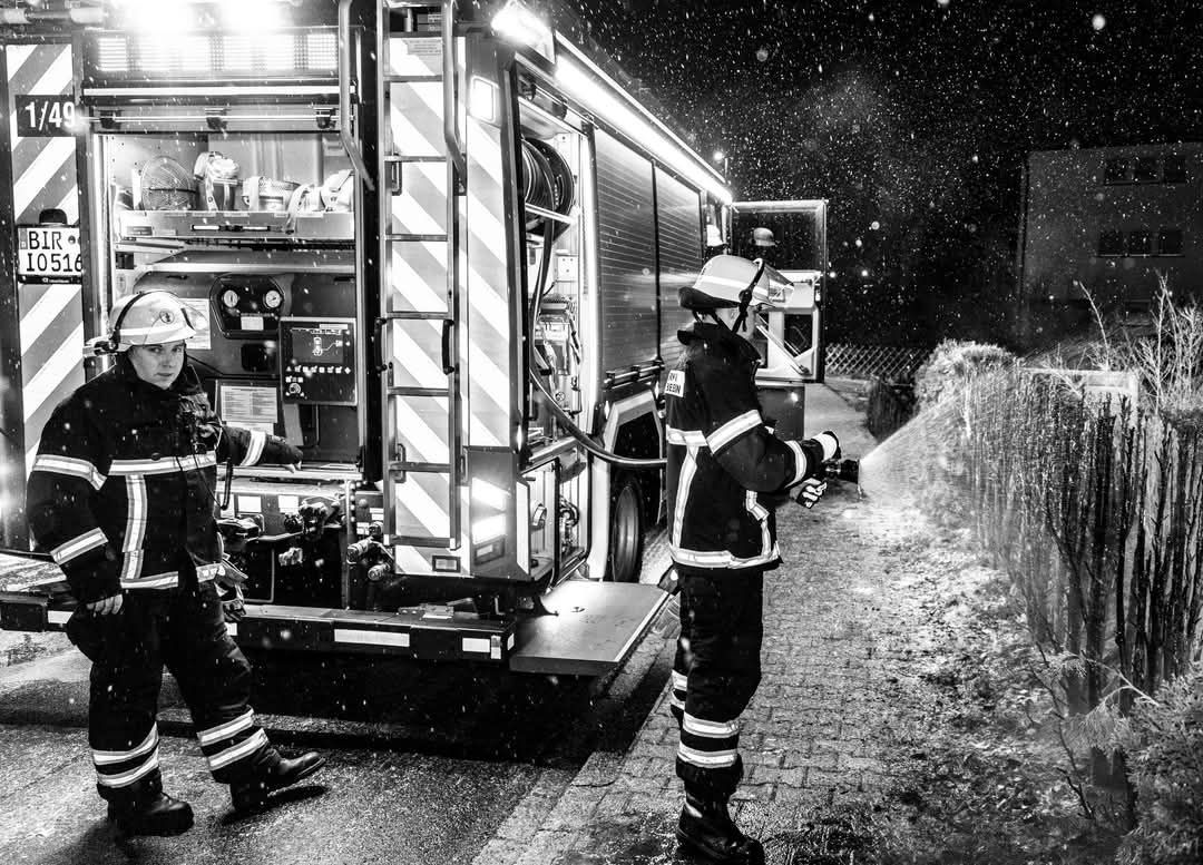 Feuerwehrmann beim Löschen der Hecke