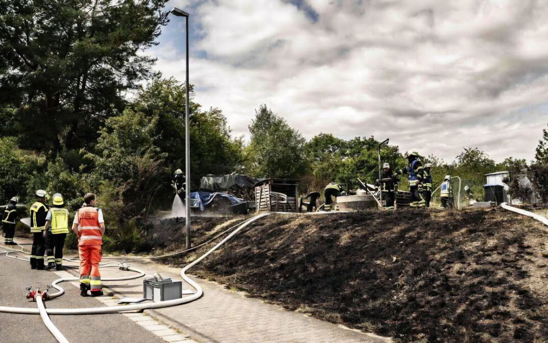 Feuerwehrangehörige löschen einen Hang