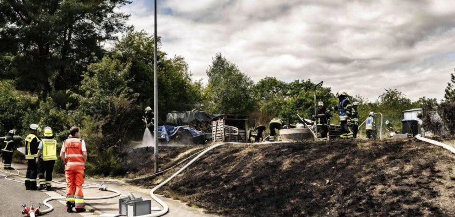 Feuerwehrangehörige löschen einen Hang