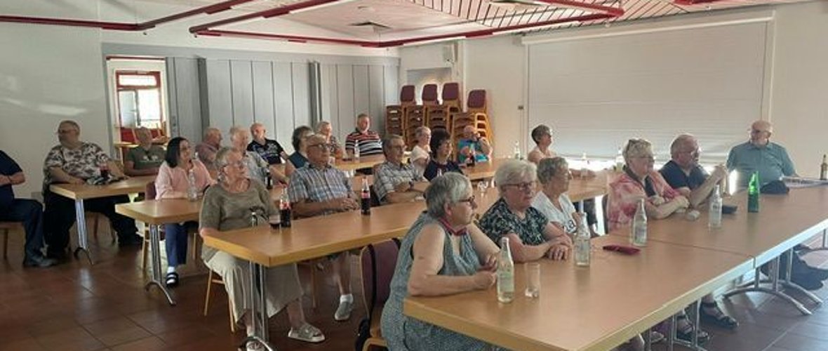 Alterskameraden sehen sich die Fotovorführung von Udo Schuff an